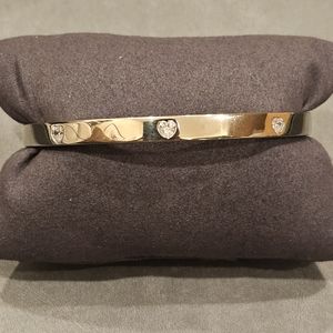 Heart shape Cubic Zirconia bangle set in sterling silver. Push lock closure.